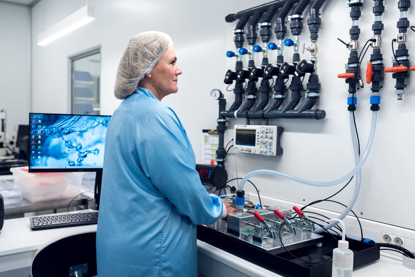 Saint-Gobain employee operator calibrating flow sensor in cleanroom