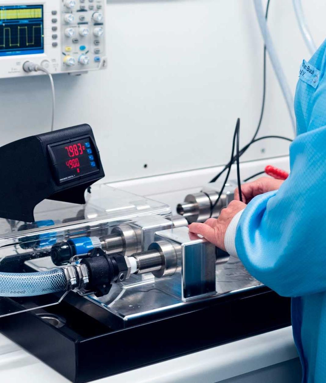 Saint-Gobain Sensors employee testing flow meters with display controller