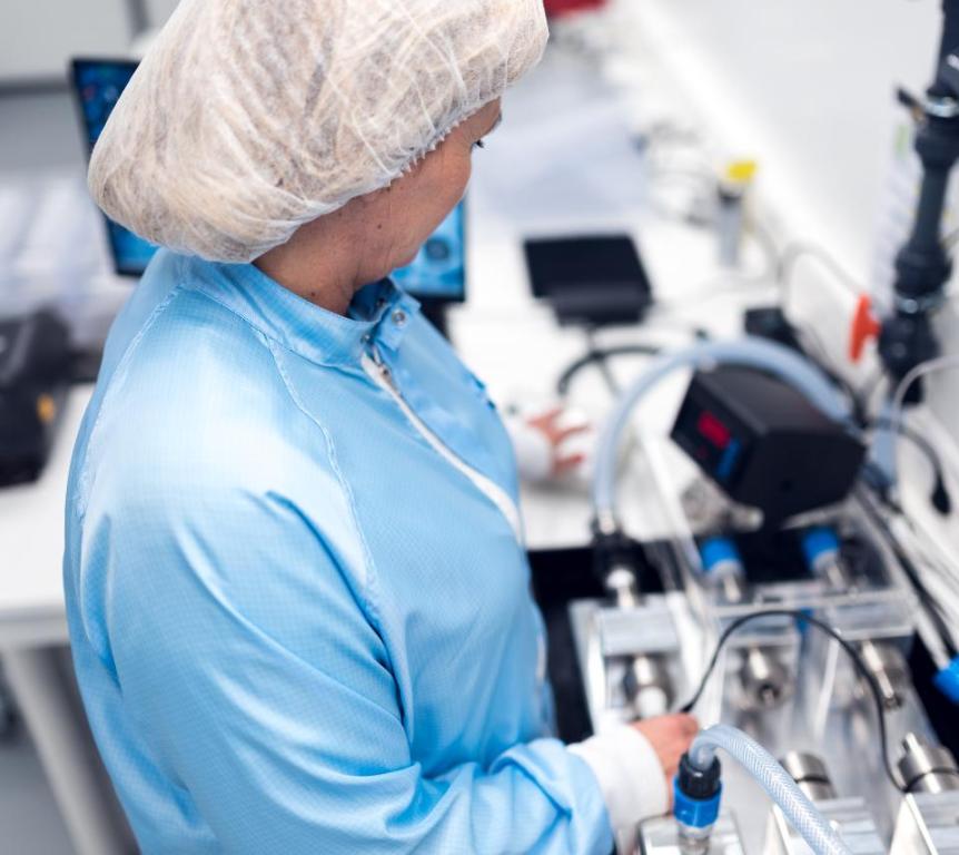 Saint-Gobain employee testing flow meter calibration in clean room
